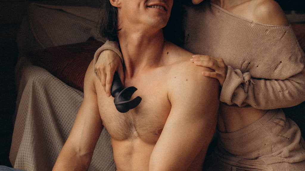 A heterosexual couple holding vibrating masturbator Man.Wand Evo colour black